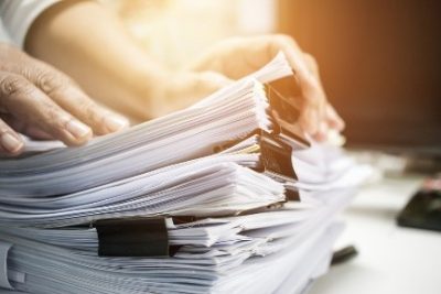Person going through a huge stack of documents
